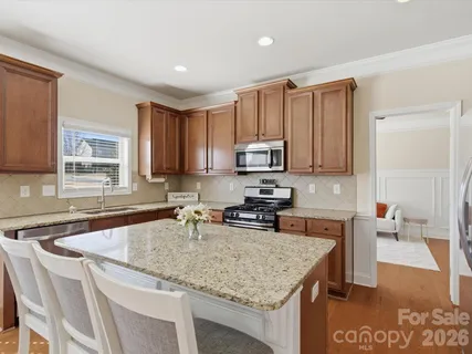 a kitchen with stainless steel appliances granite countertop a sink microwave and cabinets