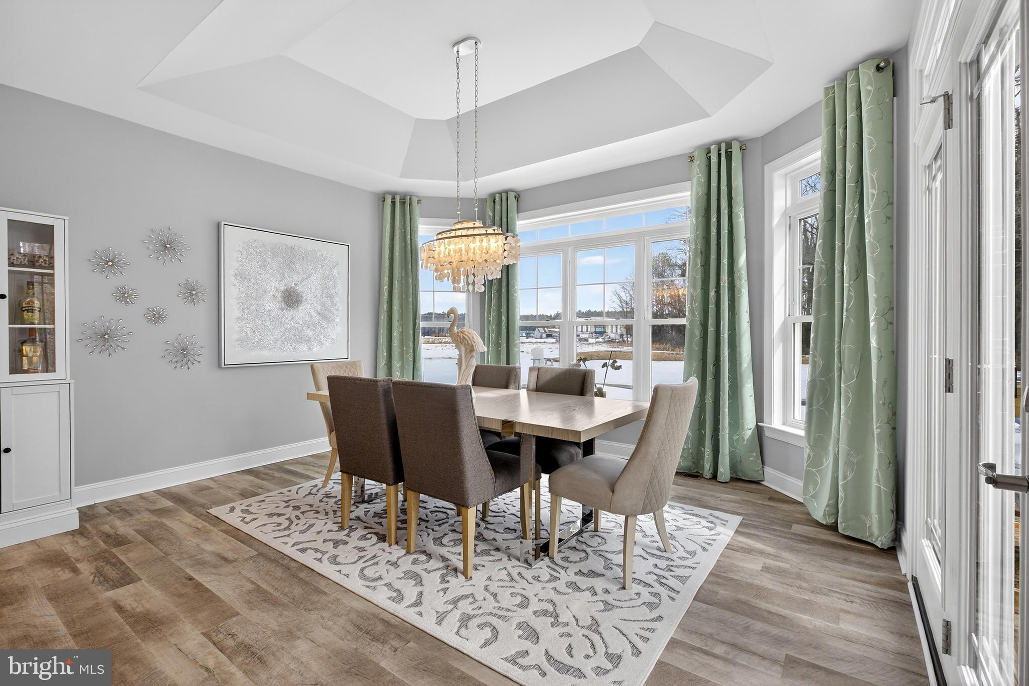 32143 Lynch Road Selbyville, DE 19975 - Photo 21 of 56 a dining room with wooden floor a glass table and chairs