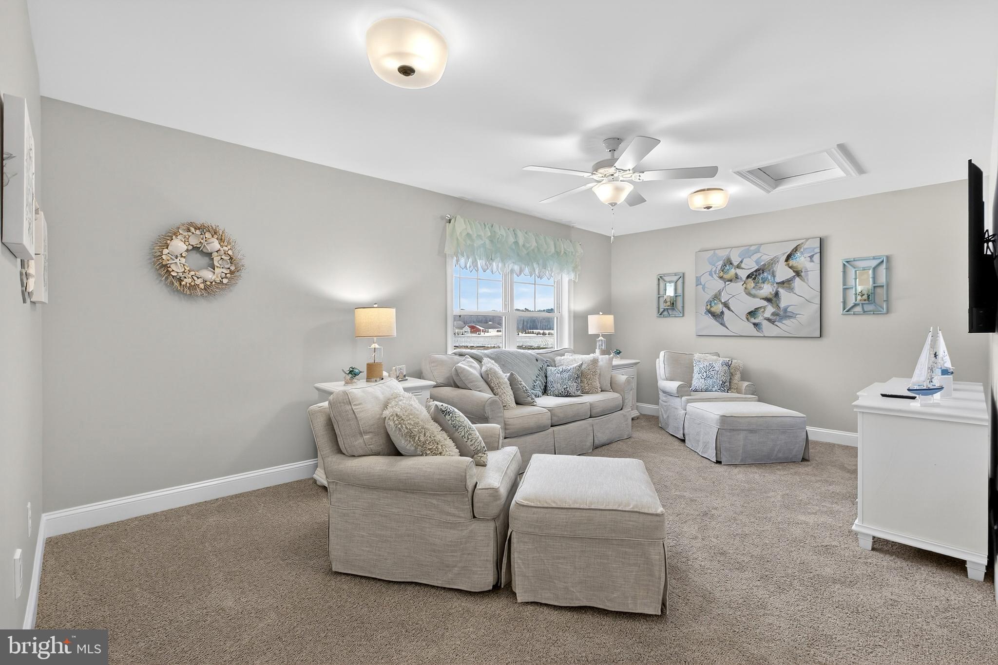 32143 Lynch Road Selbyville, DE 19975 - Photo 38 of 56 a living room with furniture a clock and a ceiling fan