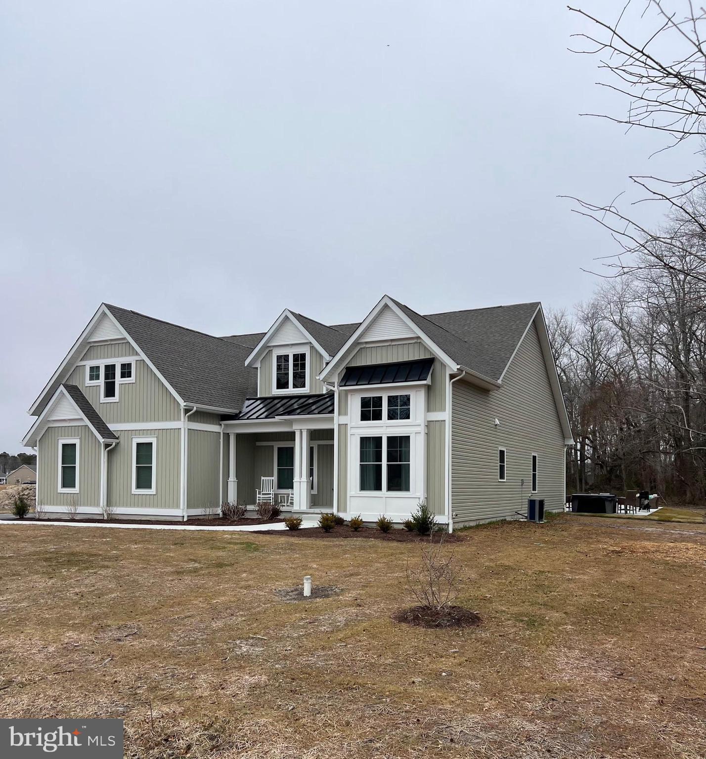 32143 Lynch Road Selbyville, DE 19975 - Photo 4 of 56 a view of a white house with a large windows and palm trees