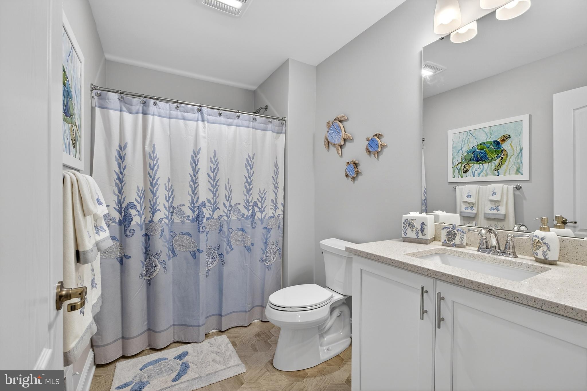 32143 Lynch Road Selbyville, DE 19975 - Photo 41 of 56 a bathroom with a granite countertop sink a toilet and a shower