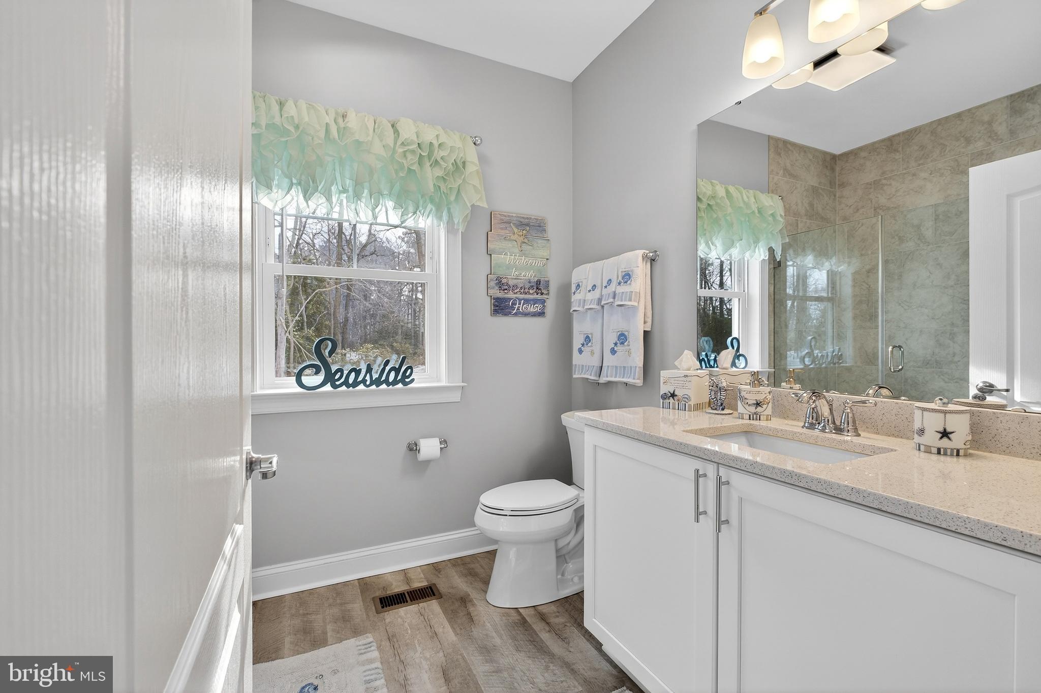 32143 Lynch Road Selbyville, DE 19975 - Photo 9 of 56 a bathroom with a double vanity sink toilet and a mirror