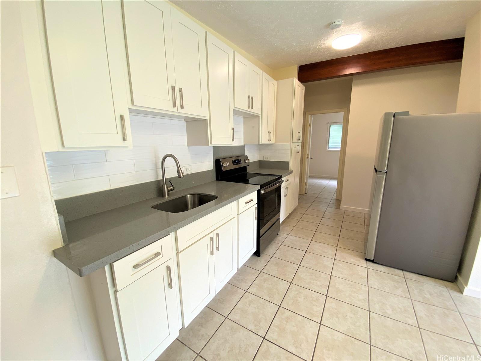 3339 Manoa Road, Unit 5 Honolulu, HI 96822 - Photo 5 of 13 a kitchen with stainless steel appliances a sink a refrigerator a counter top space and cabinets