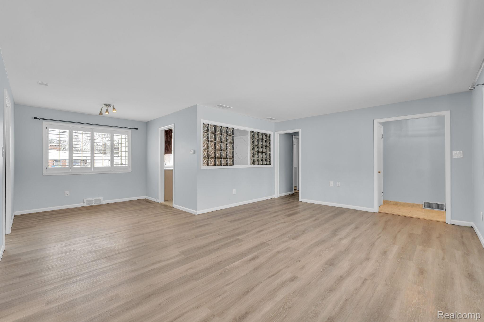 6576 Inkster Road West Bloomfield, MI 48322 - Photo 14 of 62 Unfurnished living room with light wood-type flooring and baseboards