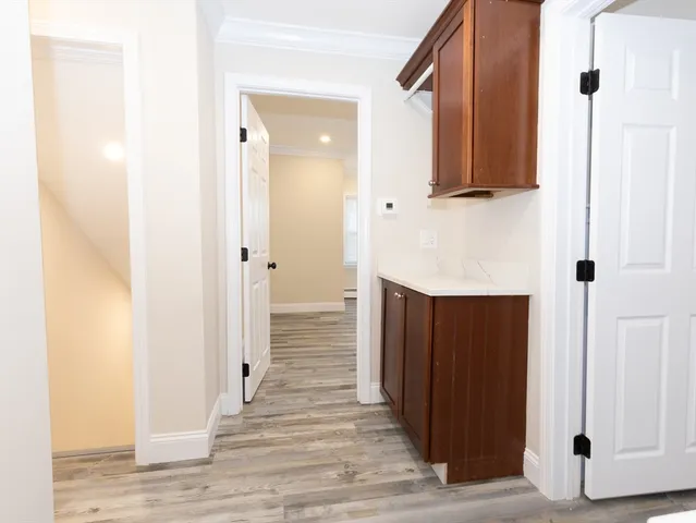 a view of a hallway with wooden floor and staircase