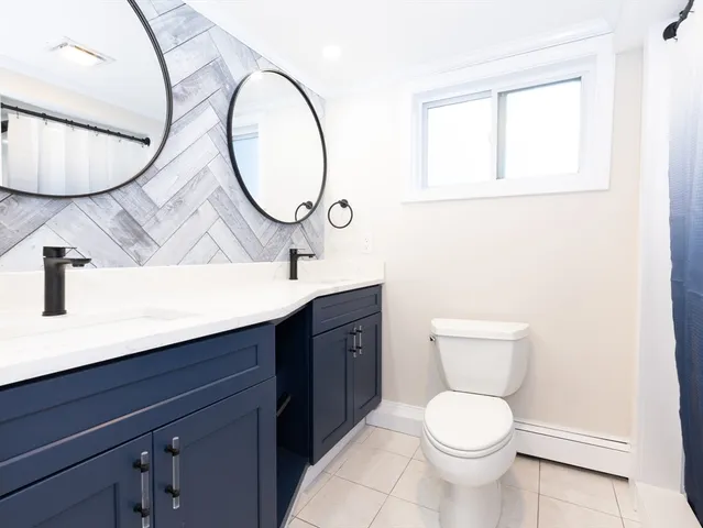 a bathroom with a toilet a sink and mirror