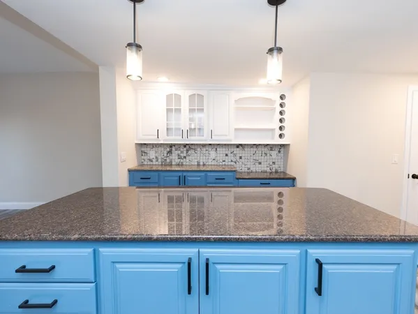 a kitchen with cabinets and chandelier