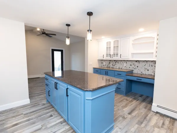 a kitchen with kitchen island granite countertop a sink and a stove