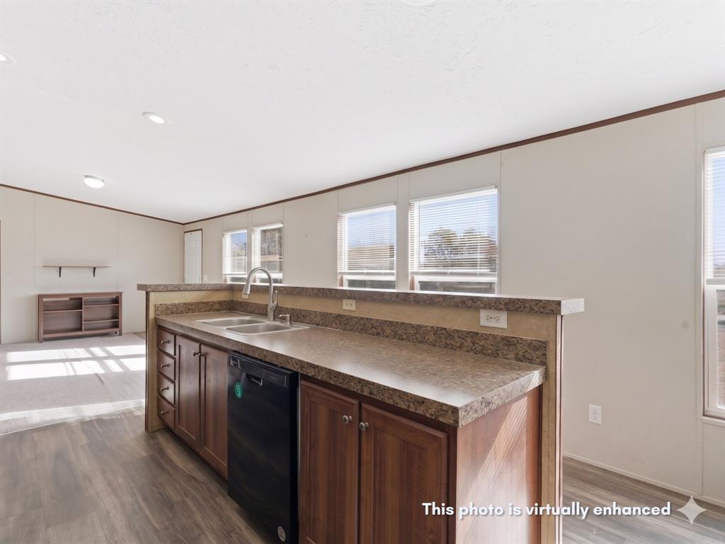 2722 Denver Road Sunset, TX 76270 - Photo 7 of 19 Kitchen island featuring a double-basin stainless steel sink with a high-arc faucet, integrated black dishwasher, and dark wood-finish cabinetry