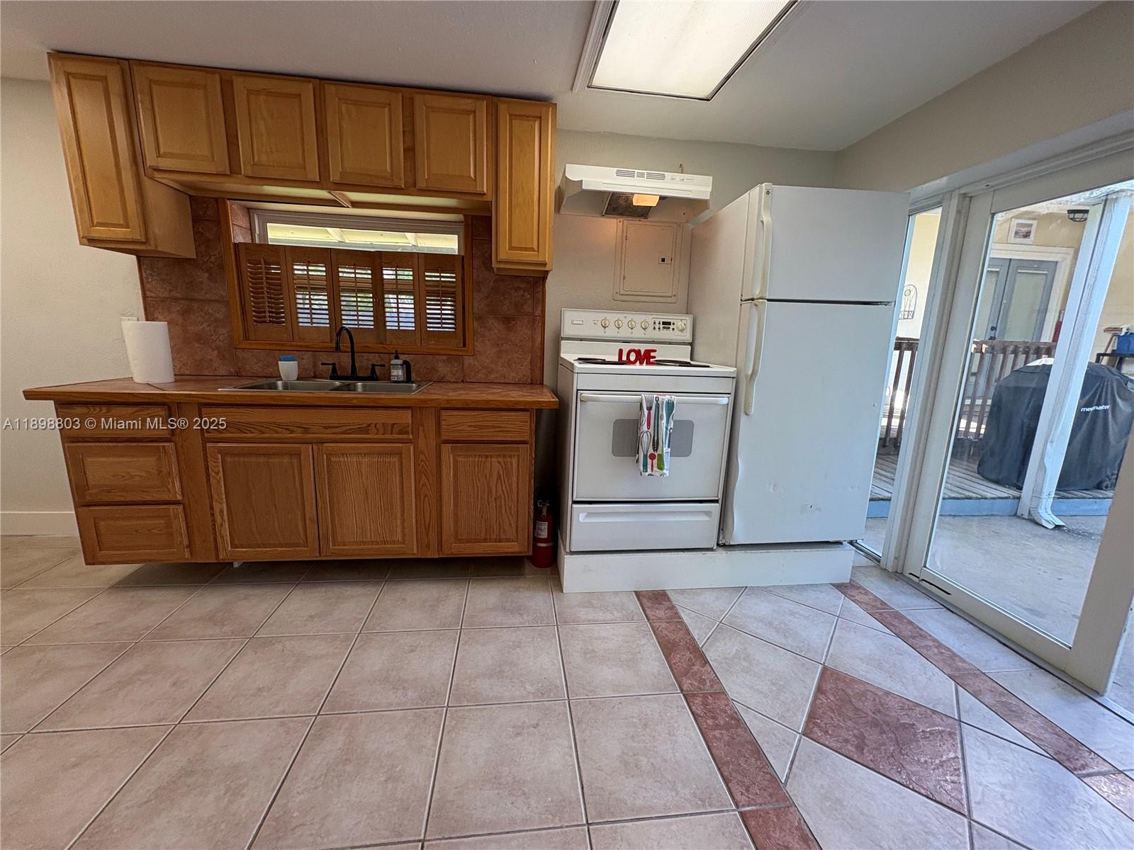 830 South Beach Street, Unit 2 Daytona Beach, FL 32114 - Photo 5 of 11 a kitchen with a refrigerator and cabinets