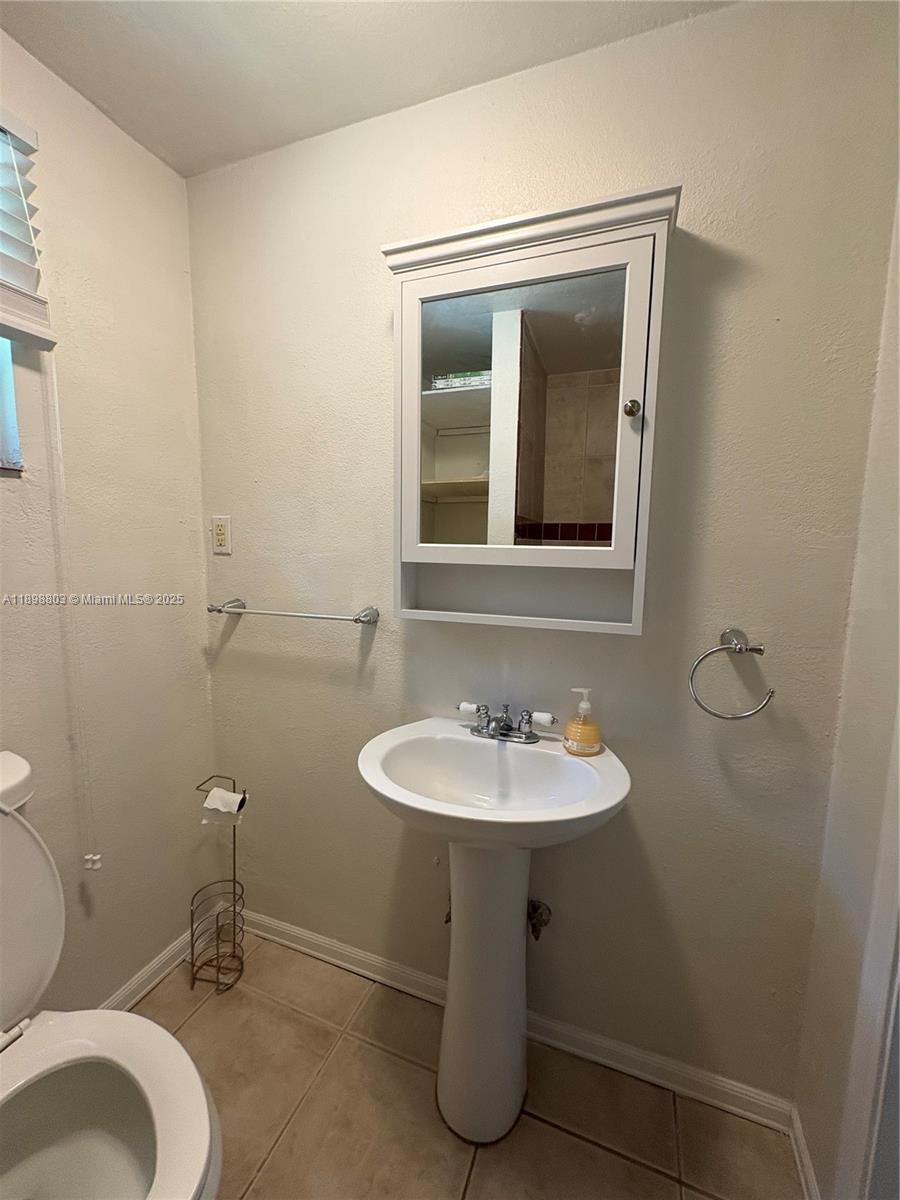 830 South Beach Street, Unit 2 Daytona Beach, FL 32114 - Photo 8 of 11 a bathroom with a sink toilet and mirror