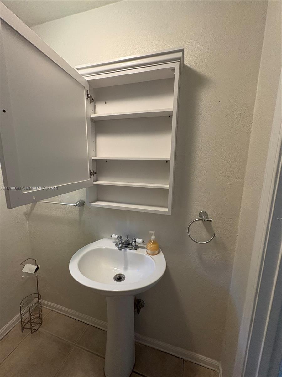 830 South Beach Street, Unit 2 Daytona Beach, FL 32114 - Photo 9 of 11 a bathroom with a sink a toilet and mirror