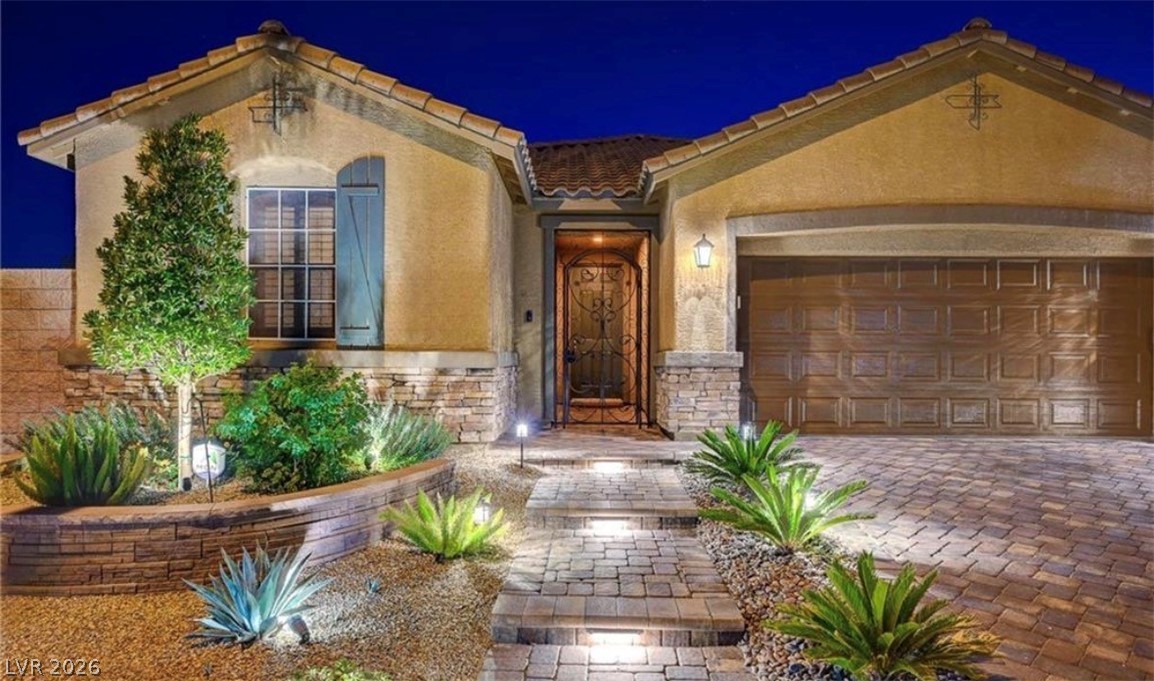 7375 Campbell Ranch Avenue Las Vegas, NV 89179 - Photo 35 of 45 Illuminated stone path leads to a charming entry, flanked by a paver driveway and desert landscaping.