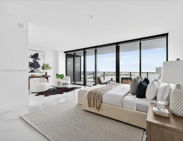 a bedroom with a bed and a large window