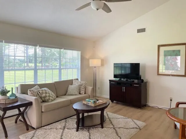 a living room with furniture a flat screen tv and a large window