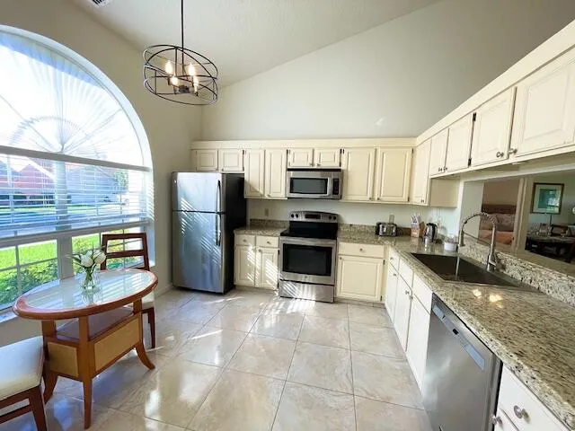 a kitchen with stainless steel appliances granite countertop a stove a sink a microwave and a refrigerator