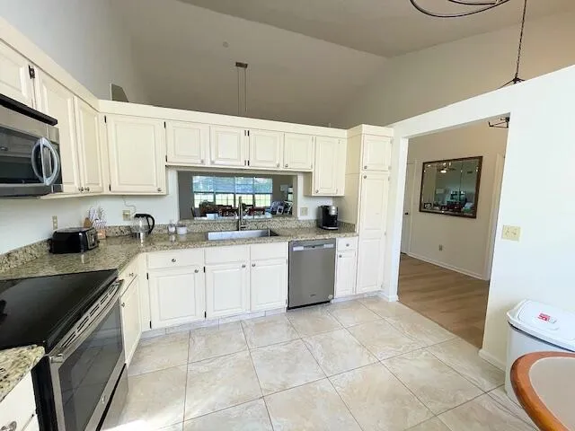 a kitchen with a sink a stove and cabinets
