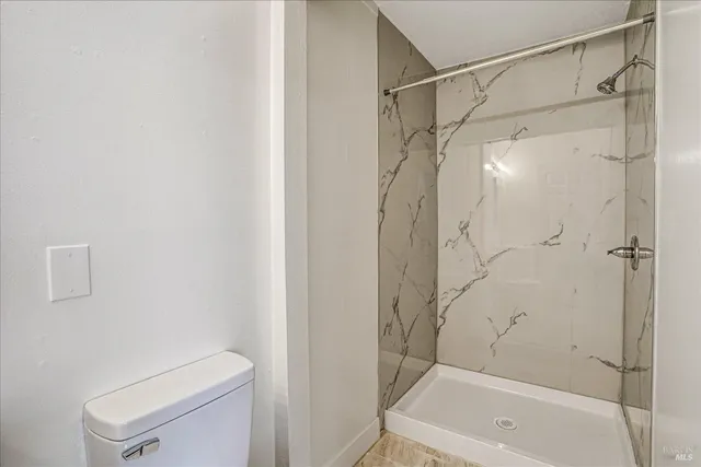 a bathroom with a shower a toilet and a shower