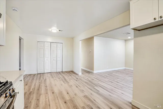 a view of an empty room with wooden floor
