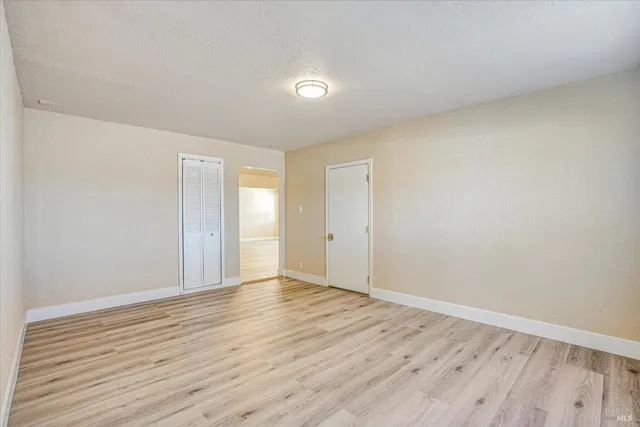 a view of an empty room with wooden floor