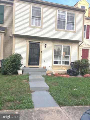 a view of house in front of a yard with potted plants