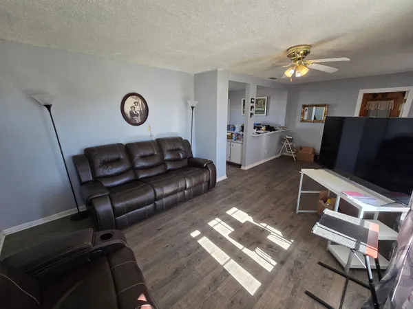 a living room with furniture and a wooden floor