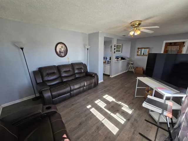 a living room with furniture and a wooden floor