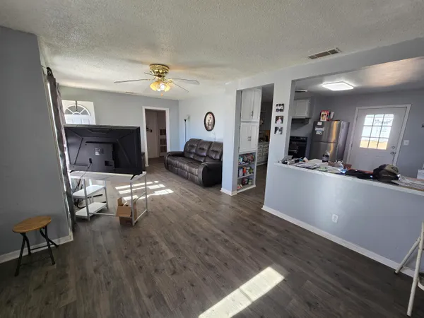 a living room with furniture and a wooden floor