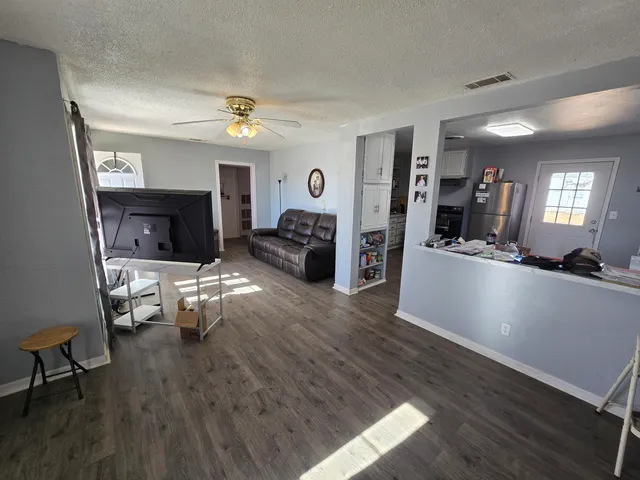 a living room with furniture and a wooden floor
