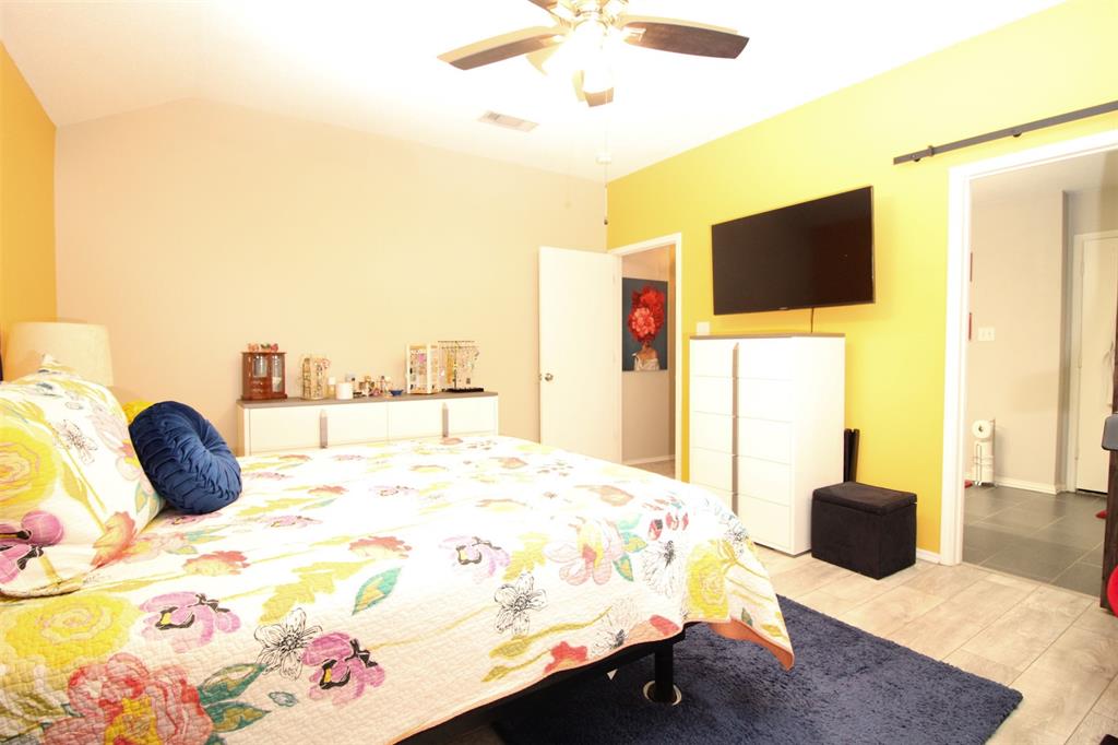 1606 Tyler Terrace Mansfield, TX 76063 - Photo 15 of 36 a bedroom with a bed and a flat tv screen on dresser