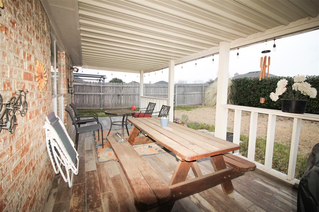 1606 Tyler Terrace Mansfield, TX 76063 - Photo 29 of 36 a view of a patio with table and chairs with wooden floor and fence