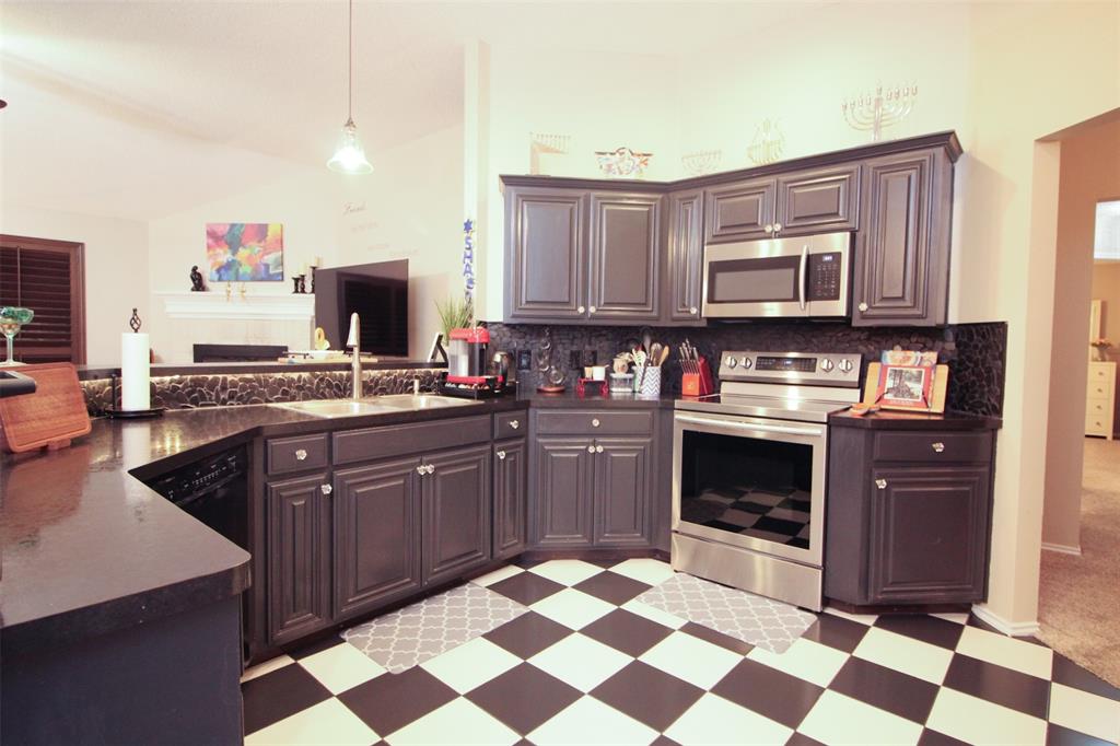 1606 Tyler Terrace Mansfield, TX 76063 - Photo 7 of 36 a kitchen with stainless steel appliances granite countertop a stove a sink and a microwave