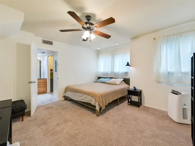 a spacious bedroom with a bed and a chandelier