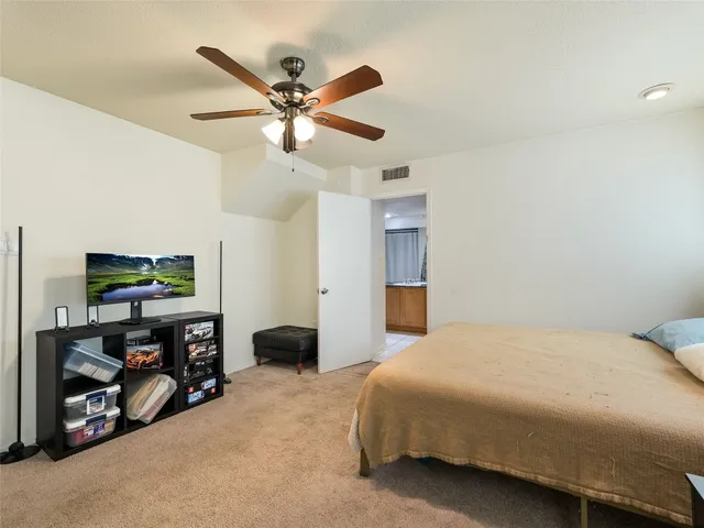 a bedroom with a bed and a flat tv screen on dresser