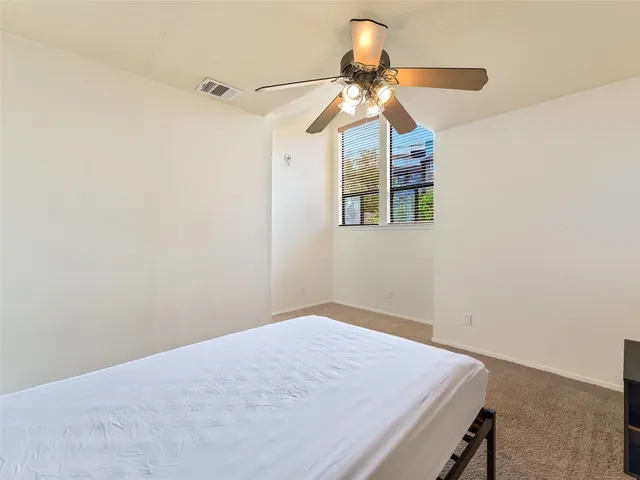 a bedroom with a fan and a chandelier fan