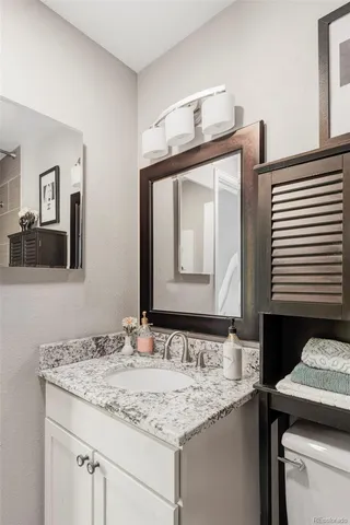 a bathroom with a granite countertop sink and a mirror