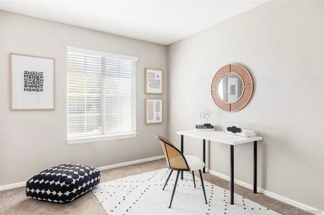 a view of a workspace with furniture and a window