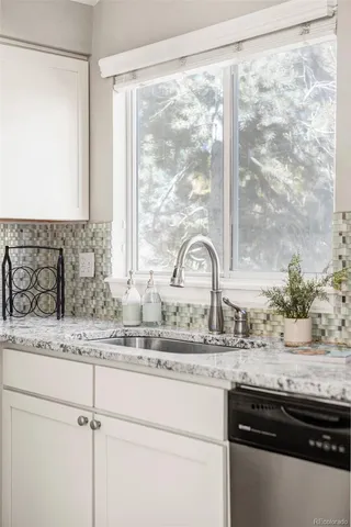 a sink a granite counter top a window and a sink