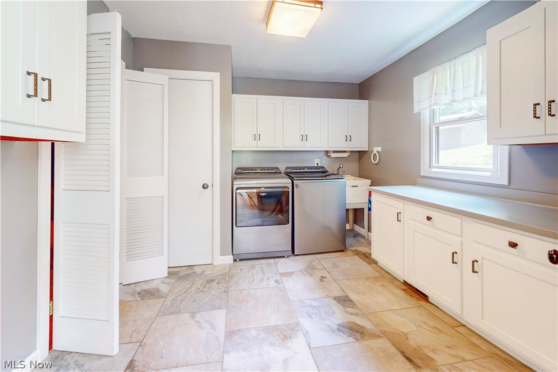 86532 North Bay Road Scio, OH 43988 - Photo 29 of 48 Spacious utility room featuring white cabinetry, extensive countertop space, patterned tile flooring, and a utility sink