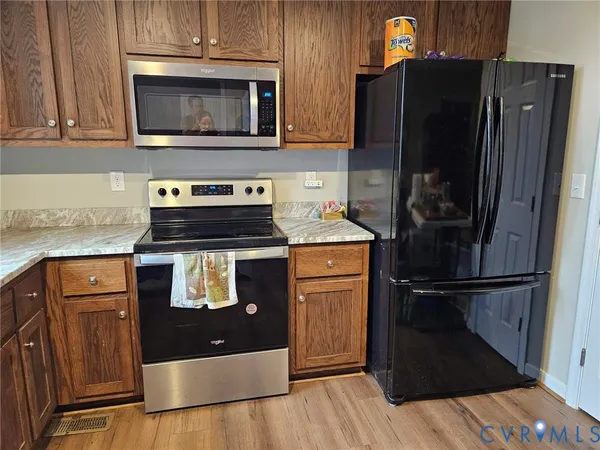 a kitchen with stainless steel appliances granite countertop a refrigerator and a stove top oven