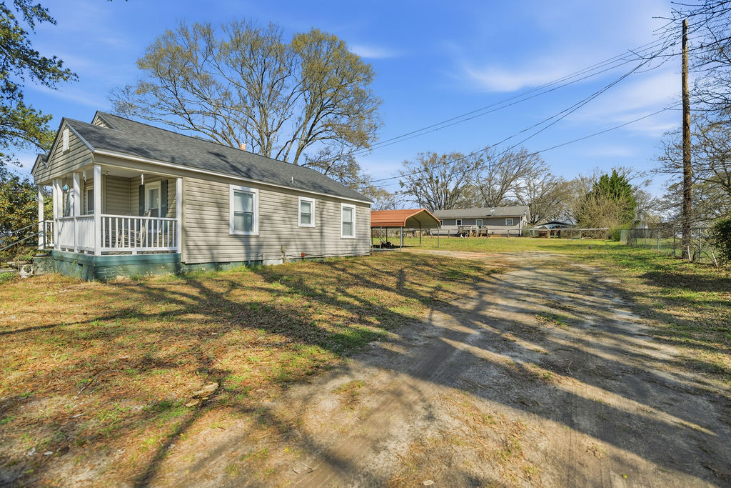 This charming home features a welcoming porch and a spacious yard, offering comfortable outdoor living.