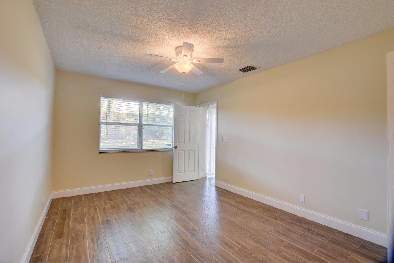 6350 Walk Circle Boca Raton, FL 33433 - Photo 12 of 29 an empty room with wooden floor chandelier fan and windows