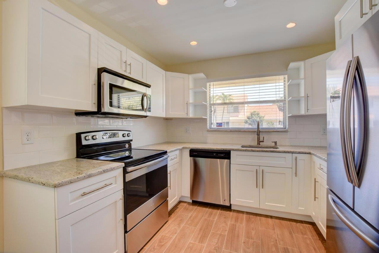 6350 Walk Circle Boca Raton, FL 33433 - Photo 7 of 29 a kitchen with stainless steel appliances granite countertop a stove a sink and a microwave