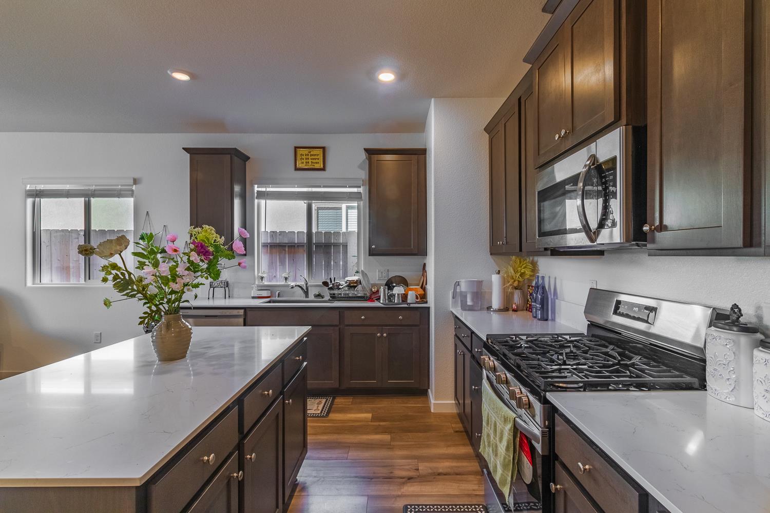 12868 Spotted Wren Circle Rancho Cordova, CA 95742 - Photo 6 of 46 a kitchen with stainless steel appliances granite countertop a sink a stove top oven a counter space and cabinets