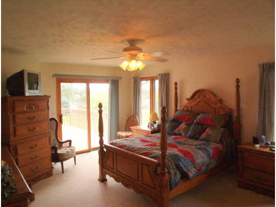 945 Lake Summerset Road Lake Summerset, IL 61019 - Photo 7 of 11 a bedroom with a bed and a chandelier