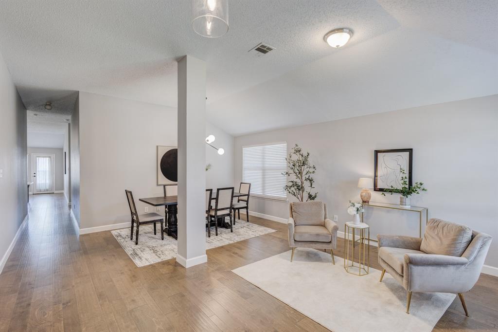 7218 Compass Point Drive Rowlett, TX 75089 - Photo 14 of 30 Living room with wood finished floors, lofted ceiling, and a textured ceiling
