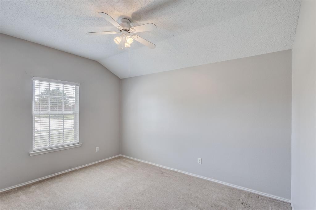 7218 Compass Point Drive Rowlett, TX 75089 - Photo 23 of 30 Carpeted spare room featuring lofted ceiling, a ceiling fan, and a textured ceiling