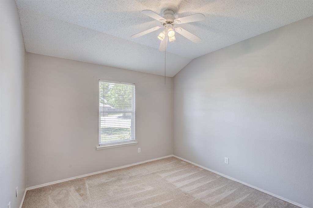 7218 Compass Point Drive Rowlett, TX 75089 - Photo 26 of 30 Spare room featuring carpet floors, a textured ceiling, lofted ceiling, and ceiling fan