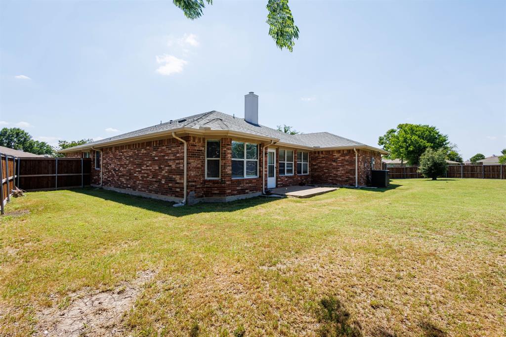 7218 Compass Point Drive Rowlett, TX 75089 - Photo 29 of 30 Back of property featuring a fenced backyard, brick siding, a patio, and a chimney