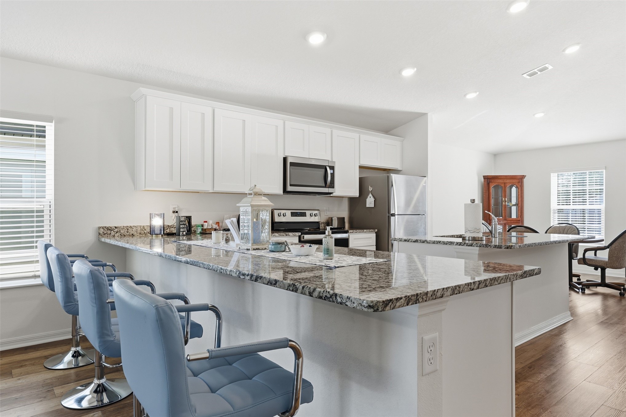 37474 Whisper Way Hilliard, FL 32046 - Photo 13 of 31 a kitchen with kitchen island granite countertop a sink cabinets and wooden floor
